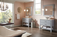 A light gray-blue dual furniture vanities and matching framed mirrors with open shelves below in a chic master bath.