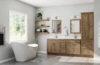 A transitional styled bathroom with light stained birch wood cabinets with a gray color palette.