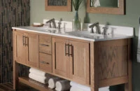 A sleek, transitional style bathroom with a spa-like design featuring a light stained wood vanity with a furniture style and an open shelf below.
