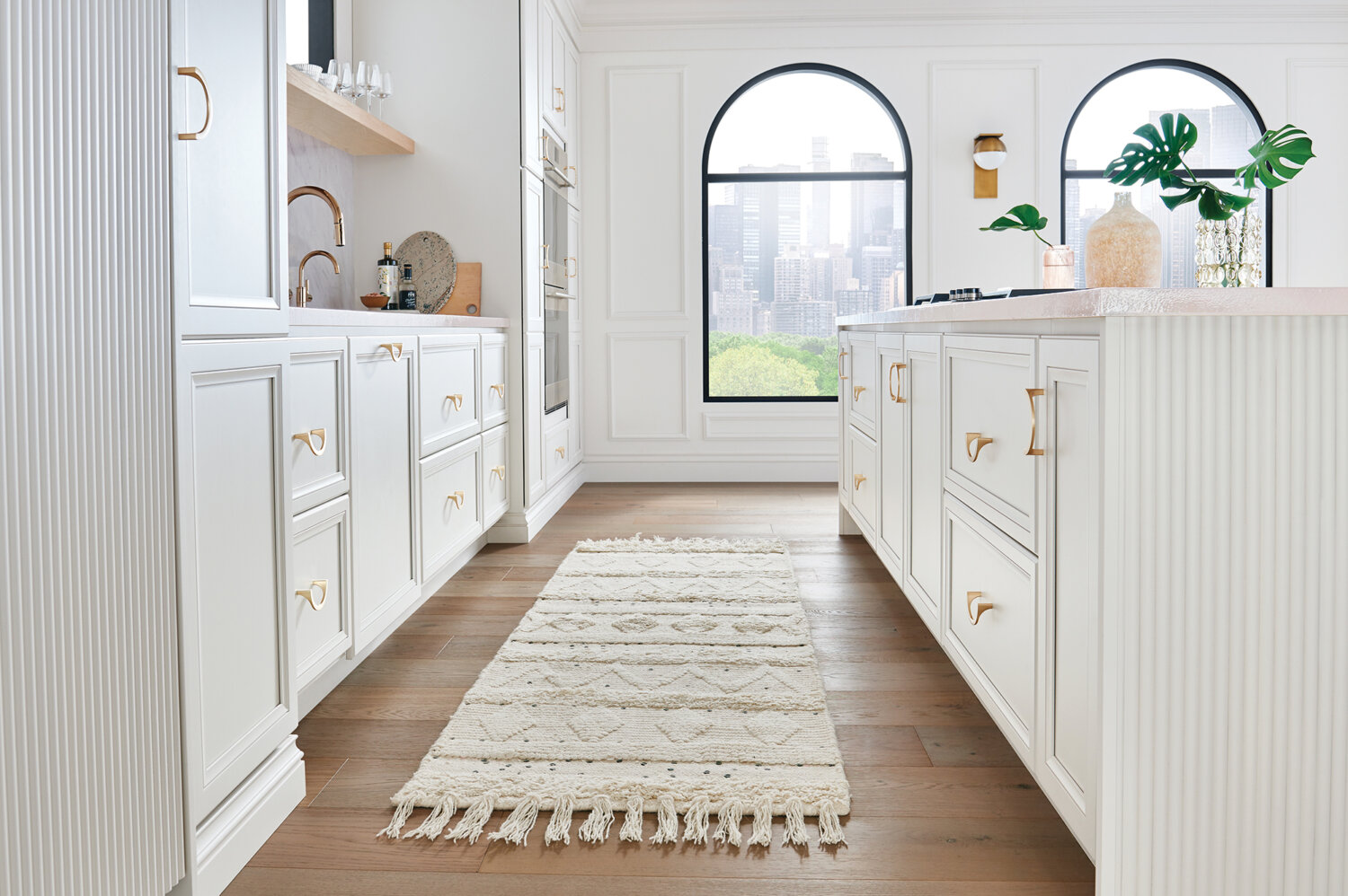 A bright, all-white kitchen with an elegant flat panel cabinet door style and a long kitchen island.