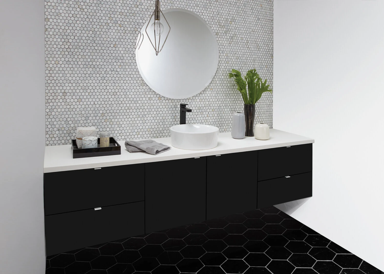 A black and white, moody bathroom design with a contemporary floating vanity in black paint.