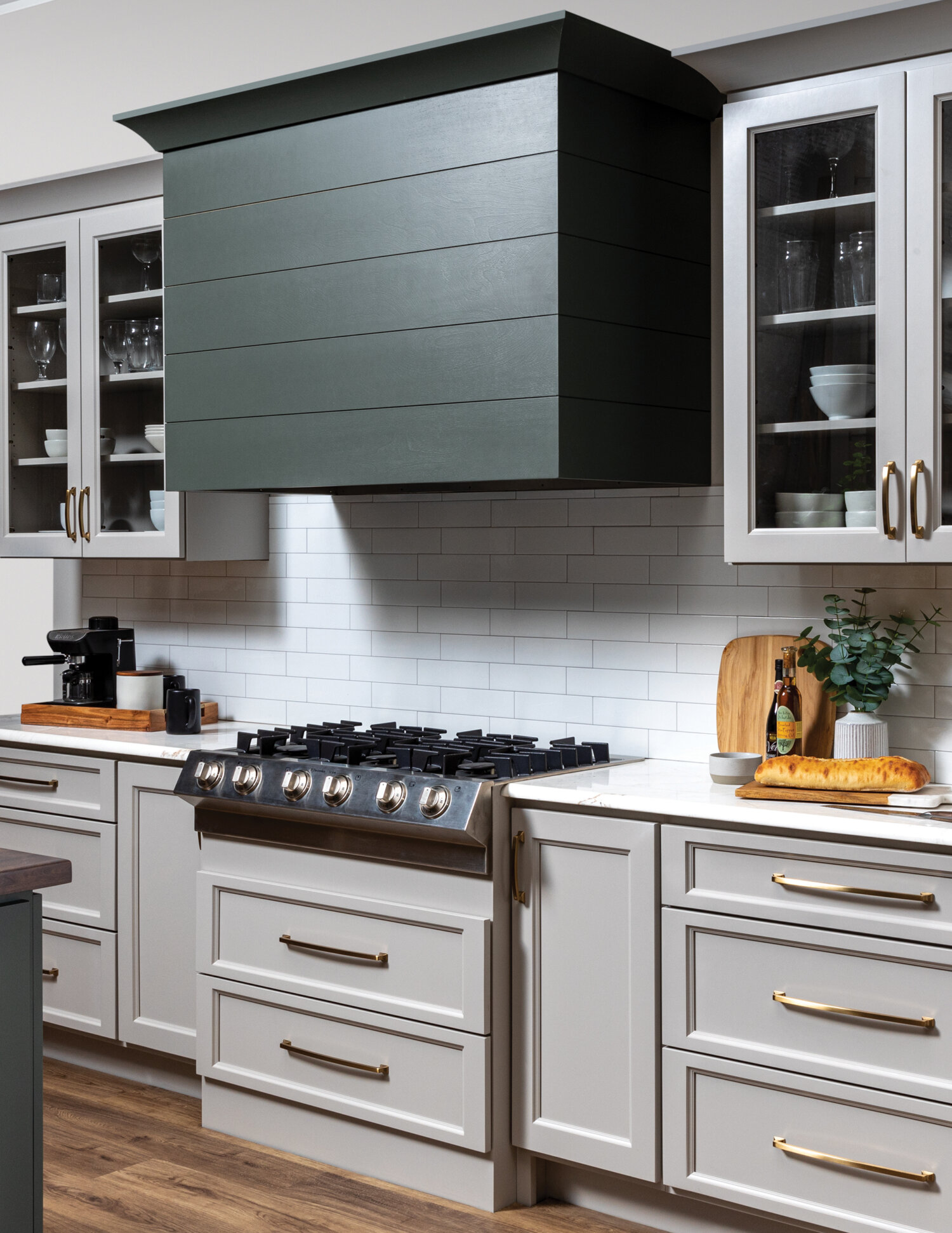 A close up of a modern wood hood with shiplap details and a hunter green painted finish.