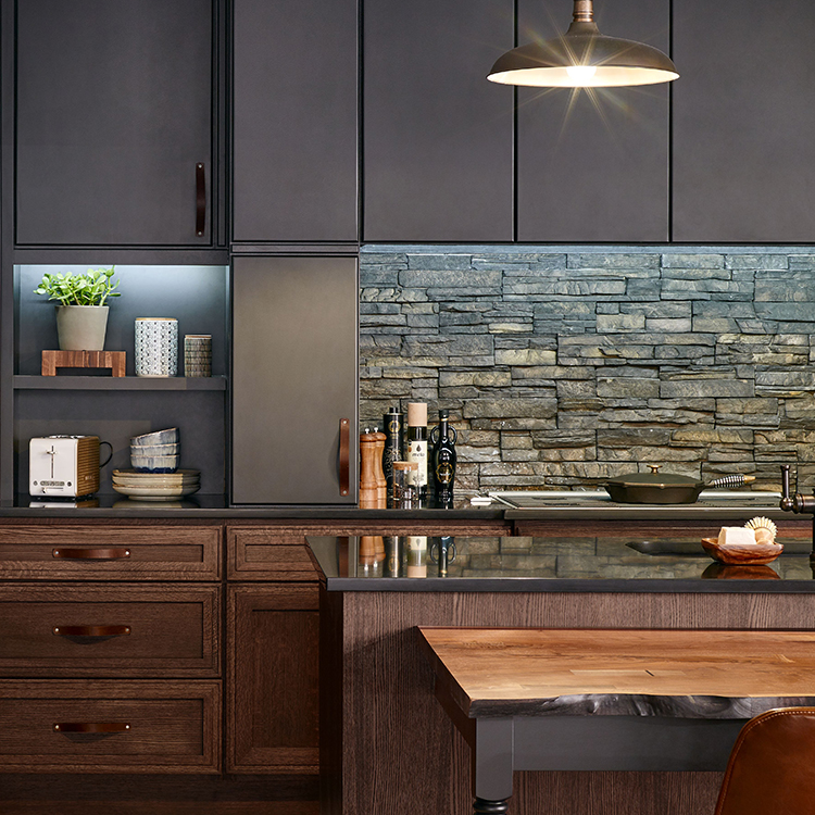 A dark and moody kitchen design with black a painted and rich-brown stained cabinets.