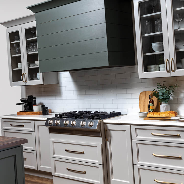 A close up of a modern wood hood with shiplap details and a hunter green painted finish.