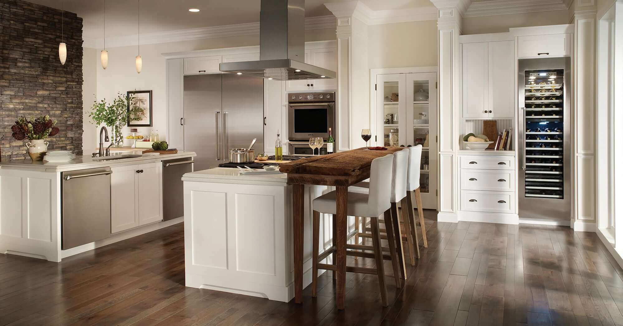 White kitchen with large center island and modern stainless steel appliances.