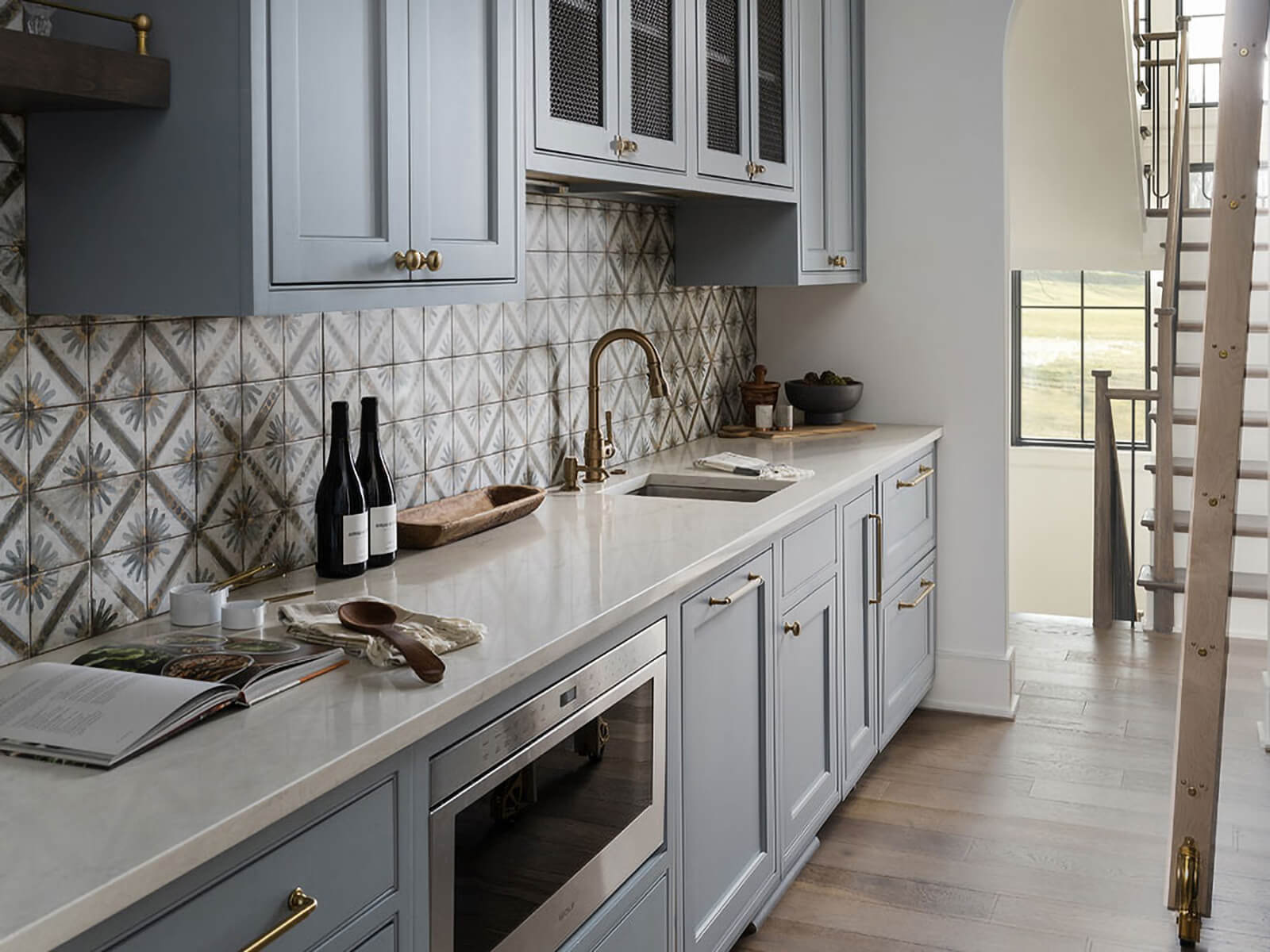 Unique tiles with cozy grey cabinets.