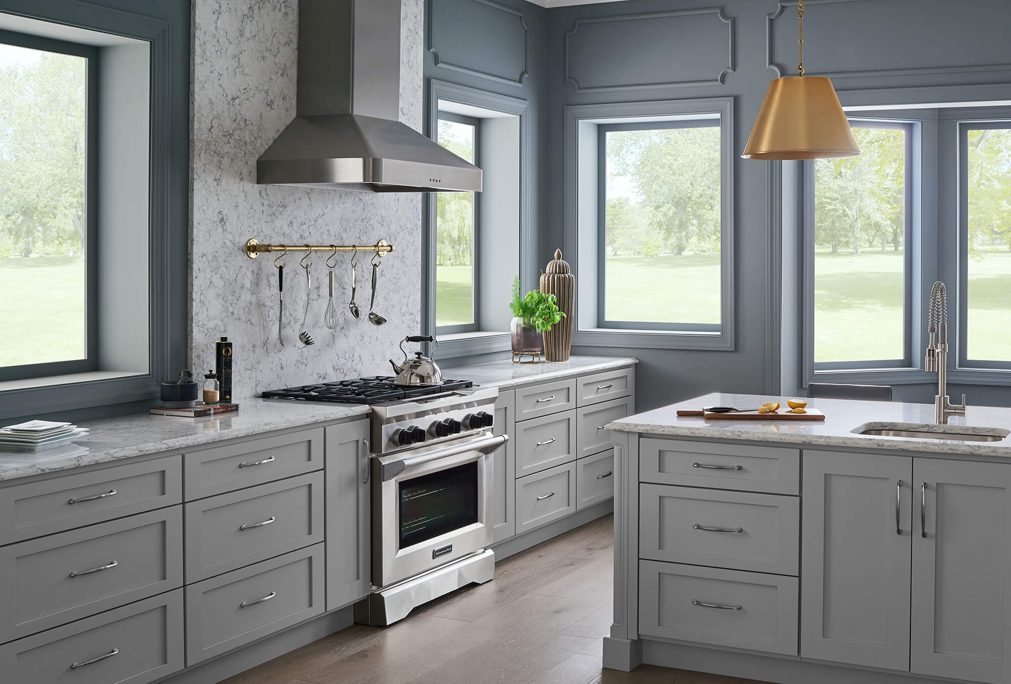 Soft gray and blue combine to make this kitchen a perfectly peaceful place to gather and enjoy some time together. This elegant kitchen design features the Lexington 3 door style in the “Lighthouse” painted finish.
