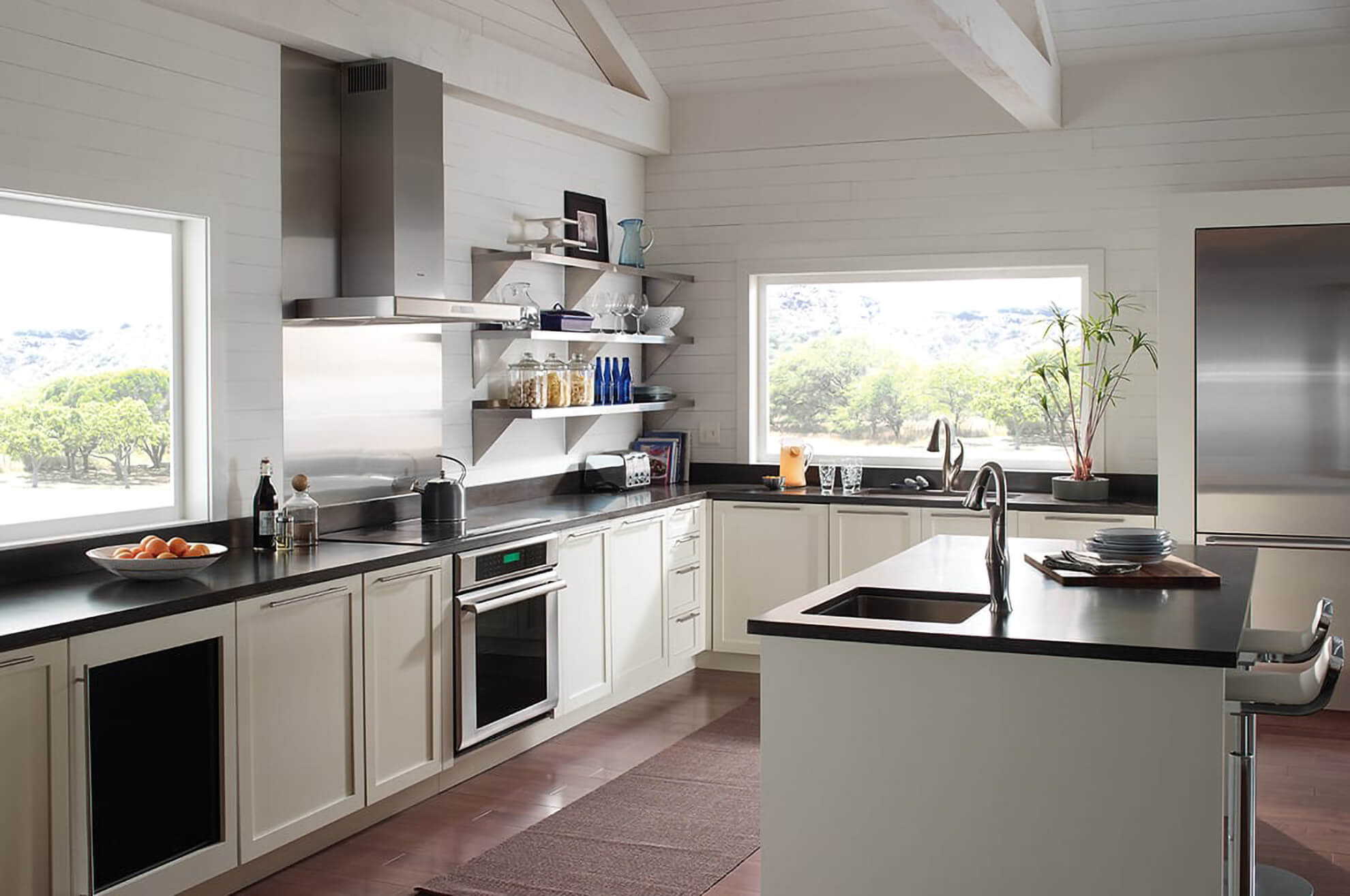 An all white, modern kitchen design with no upper cabinets.