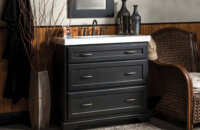 A dresser styled bathroom vanity with a black painted finish and furniture style details.