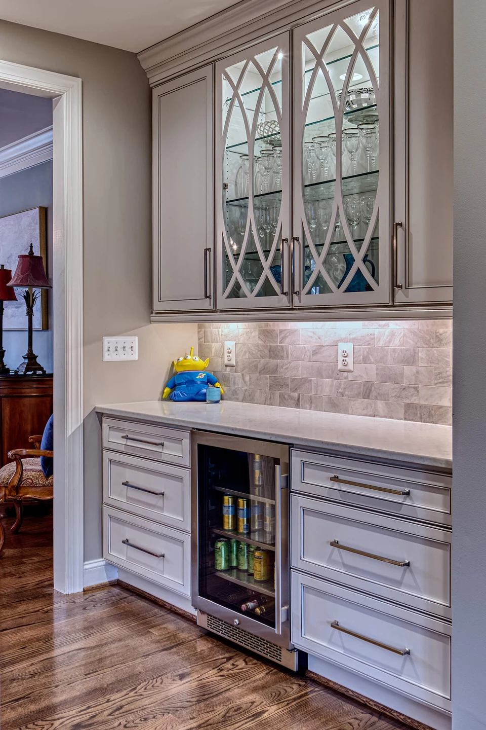 Simple butlers pantry off the kitchen with delicately detailed mullion cabinet doors for storing glassware.