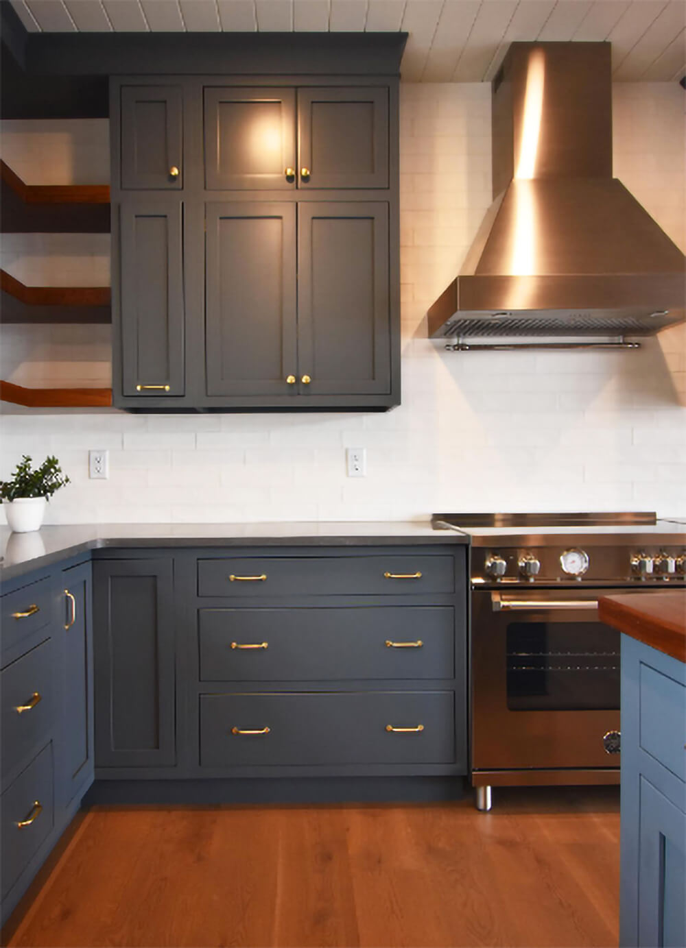 White subway tile backsplash and dark indigo cabinets.