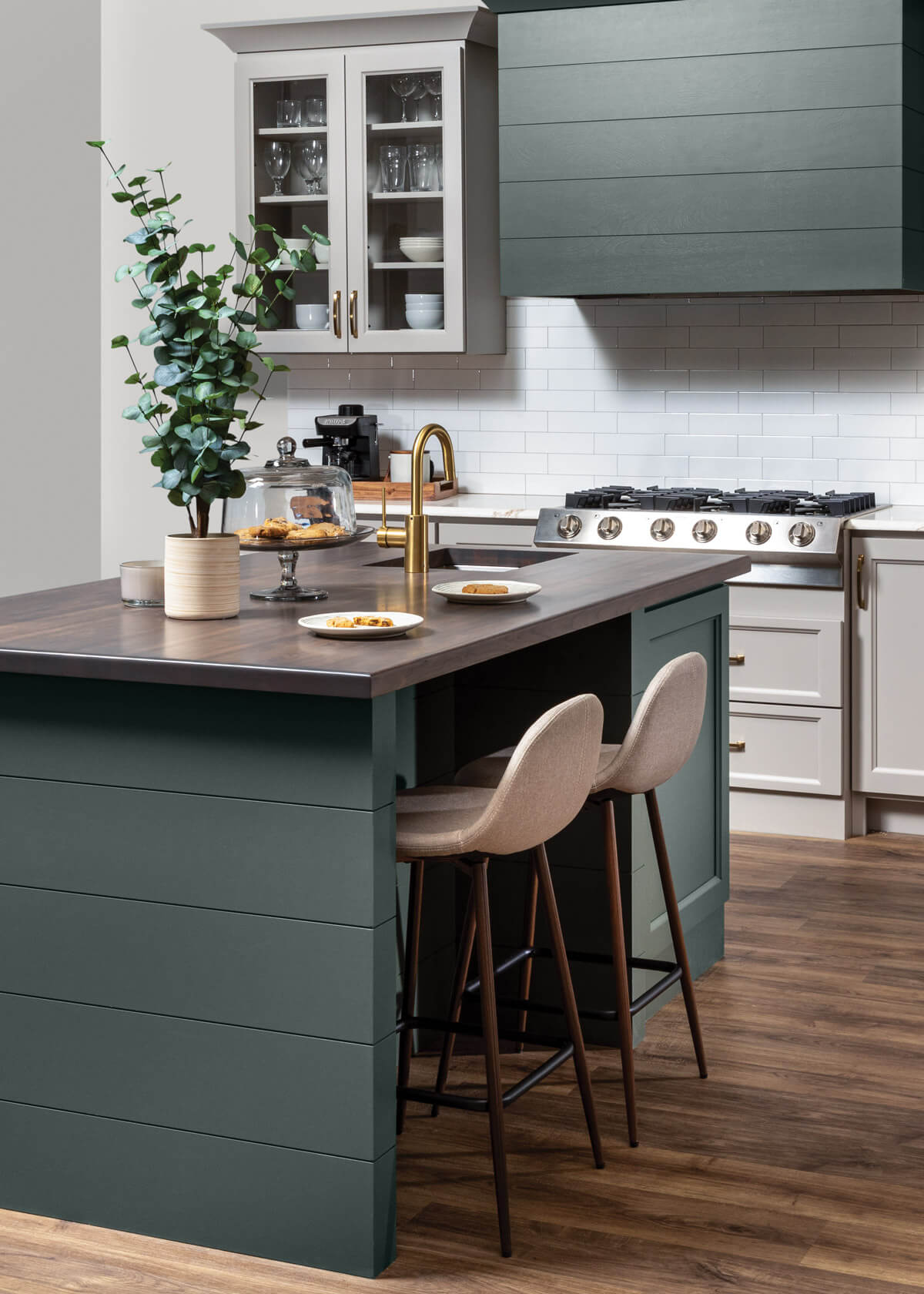 Green and beige kitchen with shiplap hood and island end cap