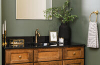 Bertch Edgewood vanity in Kodiak stain, with black legs and cozy green walls
