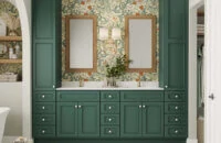 Beautiful rich green Bertch Bath cabinetry with bold floral wallpaper